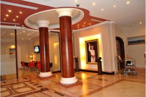 een lobby met twee grote bruine zuilen in een kamer bij Capital O 155 Dmas Hotel in Muscat