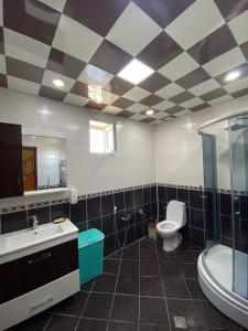 uma casa de banho com um WC, um lavatório e uma banheira em Bakı, Shagan Villa em Baku