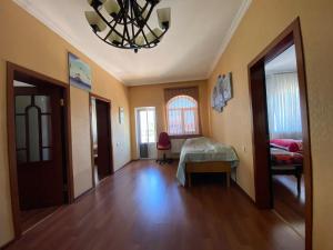 Zimmer mit einem Bett und einem Kronleuchter in der Unterkunft Bakı, Shagan Villa in Baku