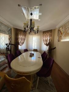 a dining room with a white table and purple chairs at Bakı, Shagan Villa in Baku