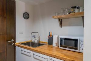 a kitchen with a sink and a microwave on a counter at [NEW] Cozy Modern Studio with Pool & Gym in Koh Samui 