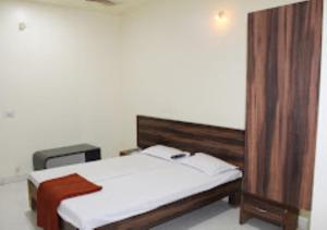 um quarto com uma cama e uma cabeceira em madeira em Hotel Udayshree Palace Latur em Lātūr