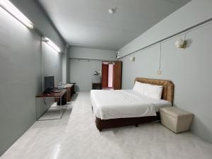 a bedroom with a bed and a desk and a television at Win Mansion in Bangkok