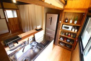 einen Blick über eine Küche mit einer Spüle und einem Kühlschrank in der Unterkunft きよかわゲストハウス in Okutama