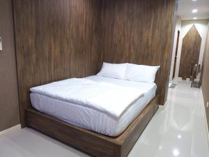 a bed in a room with a wooden wall at Baan Keang Chon Ayutthaya บ้านเคียงชล อยุธยา in Phra Nakhon Si Ayutthaya