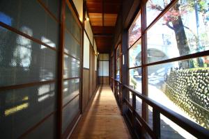 um corredor de um edifício com grandes janelas em きよかわゲストハウス em Okutama