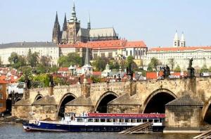 un barco en el agua junto a un puente en Prague city centre, en Praga