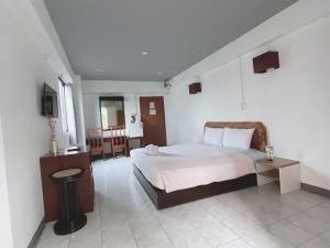 um quarto com uma cama e uma televisão em โรงแรมวินบางนา Win Bangna Hotel em Bang Na