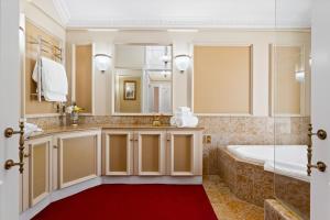 a bathroom with a tub and a large mirror at Aachen House in Auckland