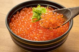 a spoonful of red caviar in a black bowl at 知床の宿Kokun Kekun in Shari