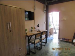 a kitchen with a table and chairs in a room at Oldy De Garden in Chiang Mai