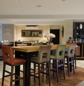 une cuisine avec une grande table et des chaises en bois dans l'établissement River City Inn, à Upington