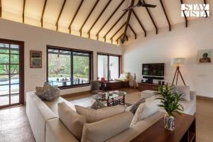 a living room with a couch and a table at Wander Beyond by StayVista - Featuring a Bali-themed abode and a refreshing swimming pool in Alibaug