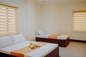 Habitación con 2 camas y sofá en RNJ Hotel, en Baguio