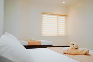 1 dormitorio con 2 camas y 1 toalla en el suelo en RNJ Hotel, en Baguio