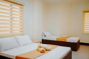 a bedroom with two beds and a window at RNJ Hotel in Baguio