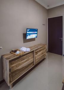a living room with a tv on a wall at Pesona Guesthouse Syariah Malang in Kotalama