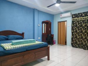 a bedroom with a bed and a blue wall at Prima Homestay Ranau in Ranau