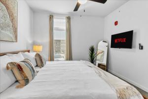 een slaapkamer met een groot wit bed en een tv aan de muur bij Near Hwyshopping Kingpoolgame Roomfitness in Rogers