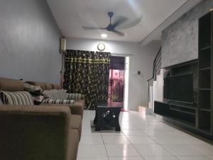 a living room with a couch and a tv at Prima Homestay Ranau in Ranau