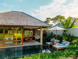 duas pessoas estão sentadas no pátio de uma villa em Kaamala Resort Ubud by Ini Vie Hospitality em Ubud