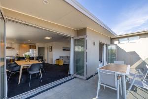 a dining room and living room with a table and chairs at Mountain View Apartment in Wanaka