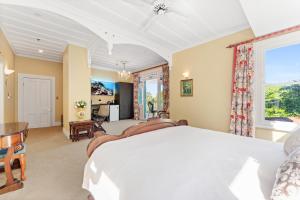 a bedroom with a large bed and a dining room at Aachen House in Auckland