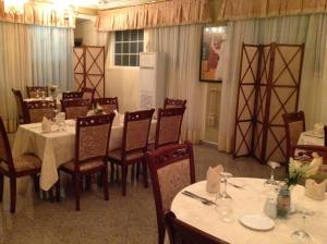 a dining room with tables and chairs in a restaurant at Charleston Hotel in Accra