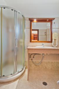 ein Bad mit einer Dusche und einem Waschbecken in der Unterkunft Royal Beach Hotel in Arkasa