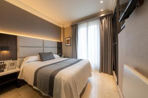 a hotel room with a bed and a window at Hotel Europa in Pamplona