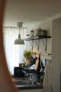 a kitchen sink with pots and pans on a shelf at Bergnestli in Oberegg