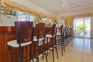 a bar with wooden chairs in a restaurant at Royal Beach Hotel in Arkasa