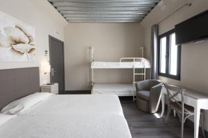 a bedroom with a bed and a bunk bed at Hostal Emeritae in Mérida