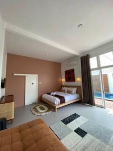 um quarto com uma cama e uma grande janela em Emka Villa Traditional Minimalist em Malang