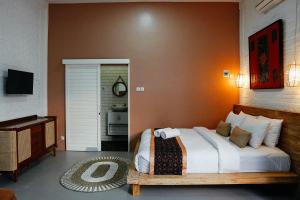 a bedroom with a large bed and a piano at Emka Villa Traditional Minimalist in Malang