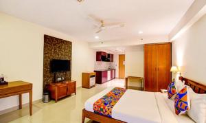 a bedroom with a bed and a television in it at FabHotel Prime Indeedcare Hotel & Resorts in Jojera