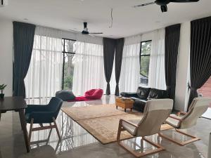 sala de estar con sofá, mesa y sillas en Jenderam Hill Villa, en Sepang