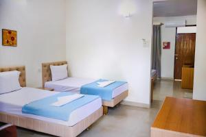 a hotel room with two beds and a table at FabEscape Orient Royal in Calangute