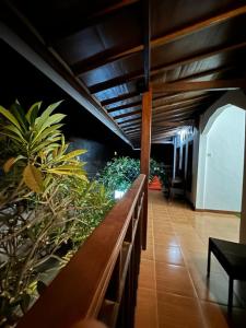 吉利特拉旺安的住宿－Tiga Dara Homestay，楼里种有植物和长凳的走廊