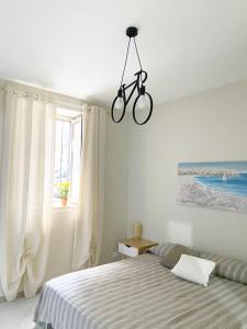 una camera da letto con una bicicletta appesa al soffitto di La casa di Angela a Monreale