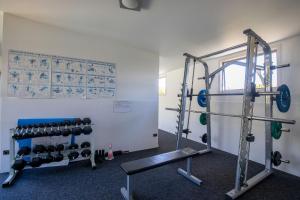 a gym with dumbbells and weights in a room at Cosy Alpine Retreat in Wanaka