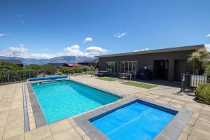 a swimming pool in front of a house at Cosy Alpine Retreat in Wanaka +7 photos