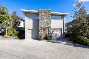 a house with a driveway with a garage at Cosy Alpine Retreat in Wanaka