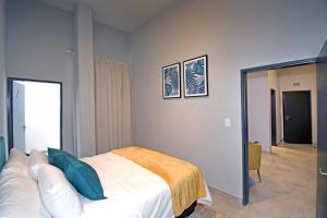 a bedroom with a white bed with blue pillows at Lux 52 Circa Apartment in Pretoria