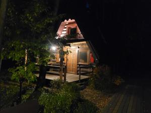 ラドムスコにあるKlimatyczne Domki - Całoroczneの夜間のポーチ付き小さなキャビン