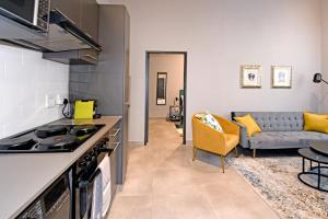 a kitchen and living room with a stove and a couch at Lux 52 Circa Apartment in Pretoria