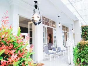 a porch with chairs and a chandelier at Victoria Bed & Breakfast in Malang