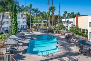 uma imagem de uma piscina num resort com mesas e cadeiras em Fairfield Inn and Suites by Marriott San Jose Airport em San Jose