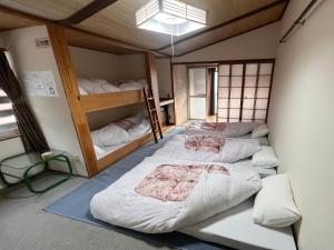 a room with four bunk beds in it at AKANE Hostel あかね天然温泉旅館 in Mitsumata