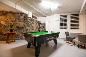 a room with a pool table in front of a stone wall at Les Géraniums in La Plaine des Cafres